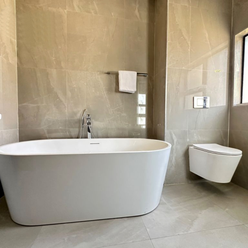 Zimbabwe full house custom bathroom featuring a freestanding bathtub, modern toilet, and sleek cabinetry